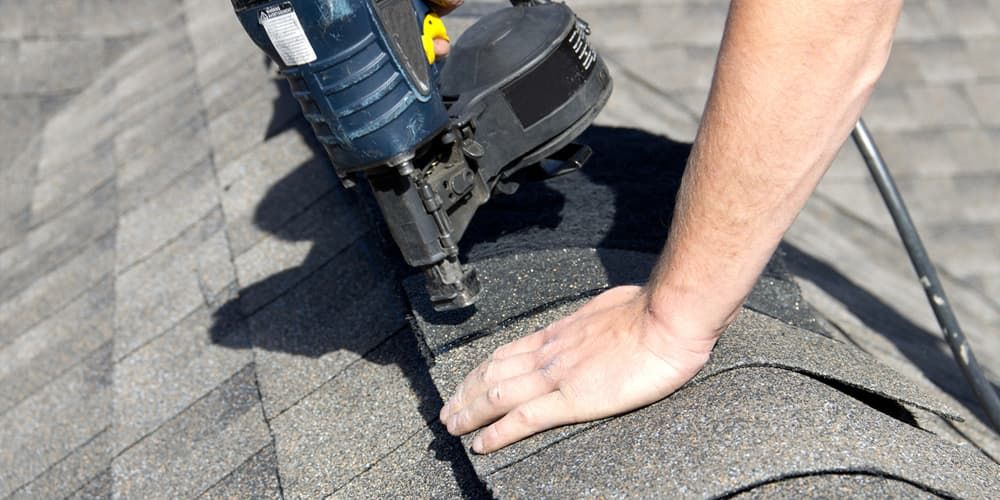 Professional roofing contractor installing Atlas shingles on a residential roof