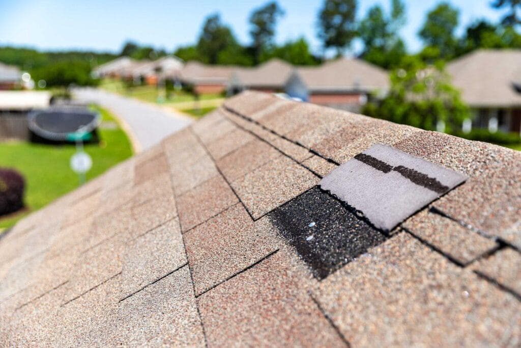 Wind-lifted shingles exposing the roof deck