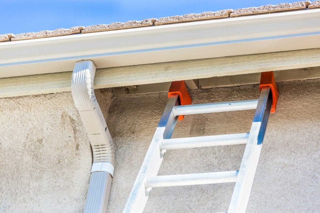 Ladder set against a gutter for cleaning