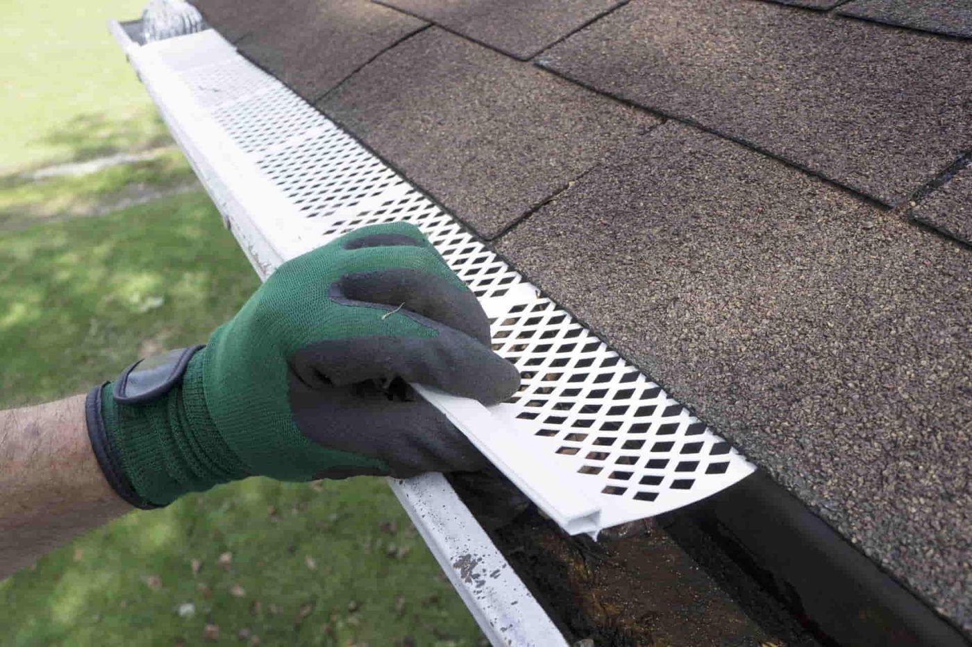 Installer fitting a gutter guard onto a gutter