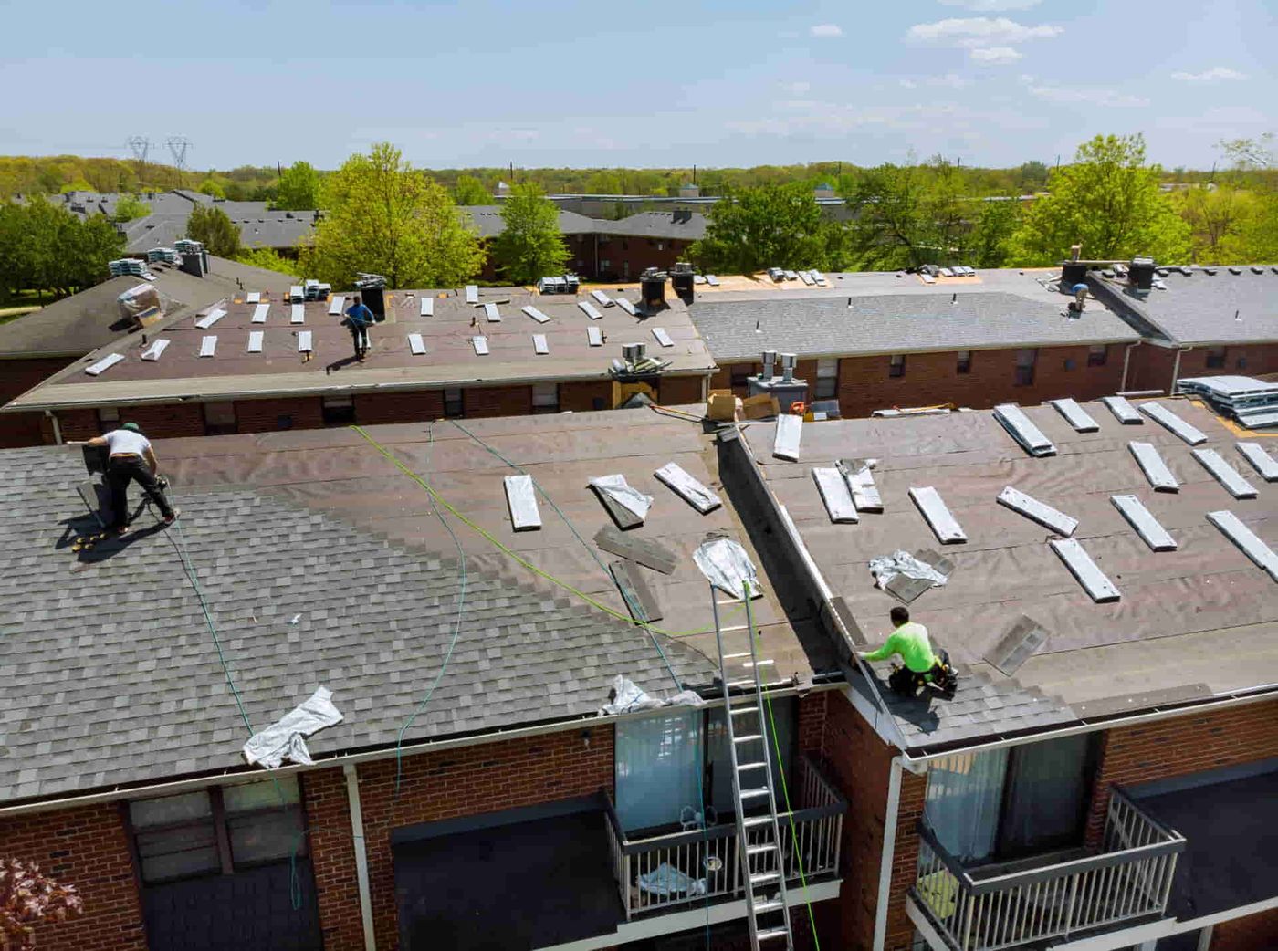 Roofing crew replacing a large residential roof
