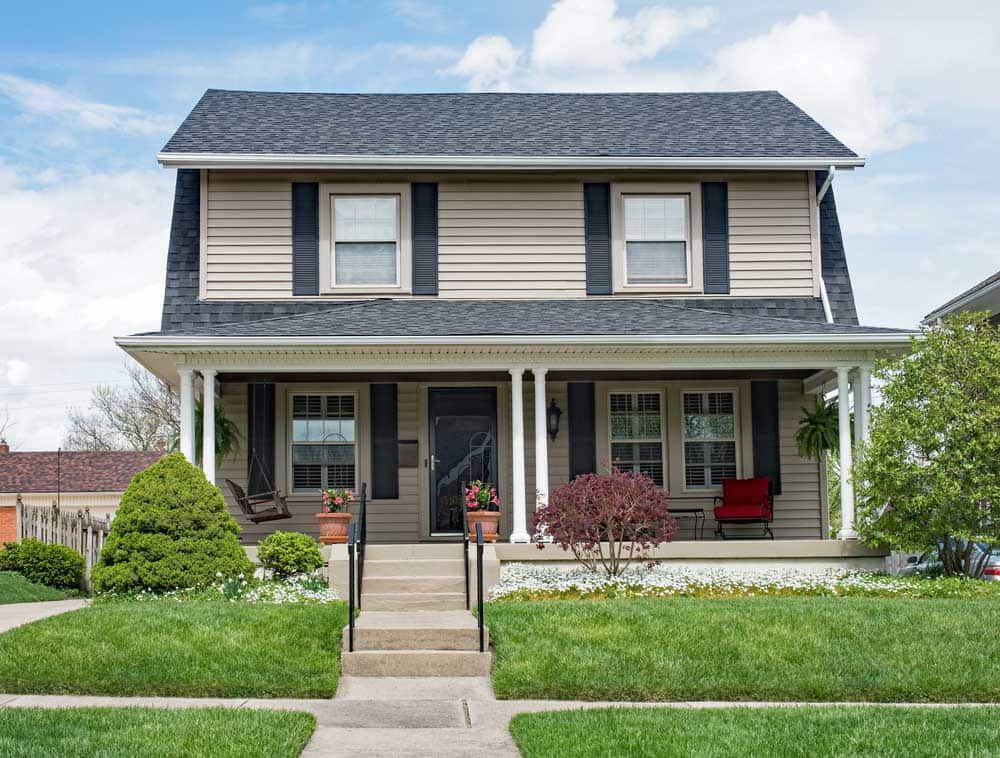 Two-storey home with a porch and a grey shingle roof