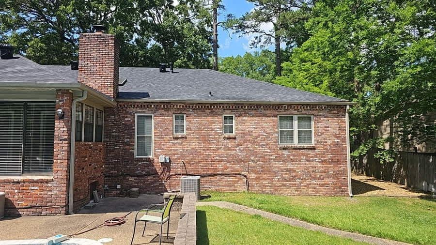 Roof replacement in progress on a brick home