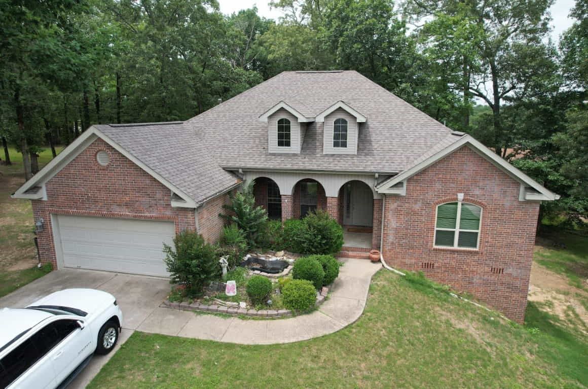 Two-storey brick home with a completed asphalt shingle roof
