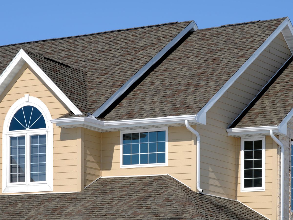 Two-storey home with a shingle roof and dormers
