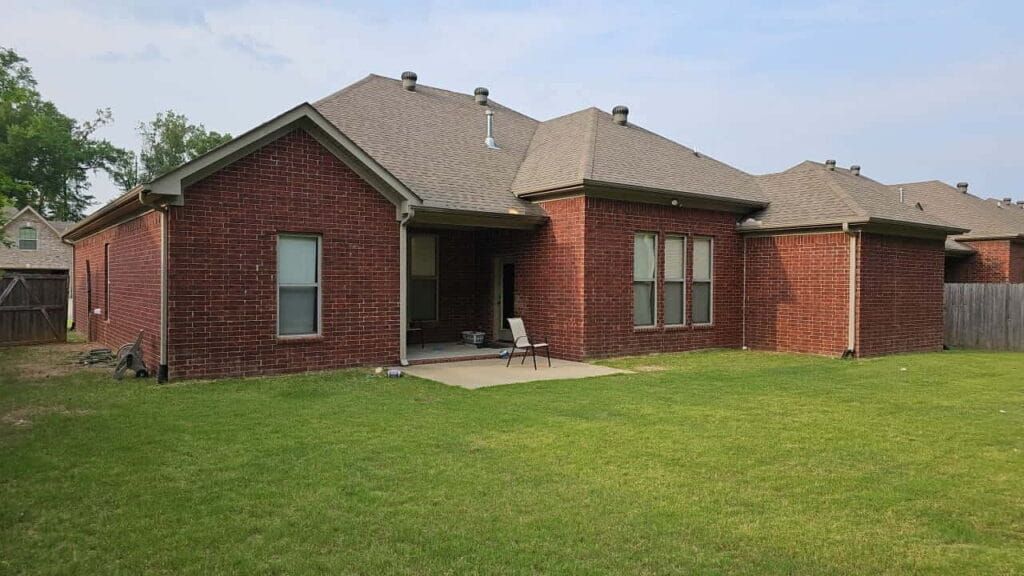 Red brick ranch home with a shingle roof