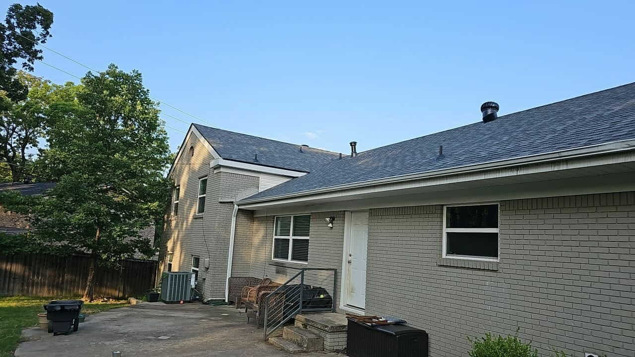 Completed roof replacement on a brick home with a rear patio