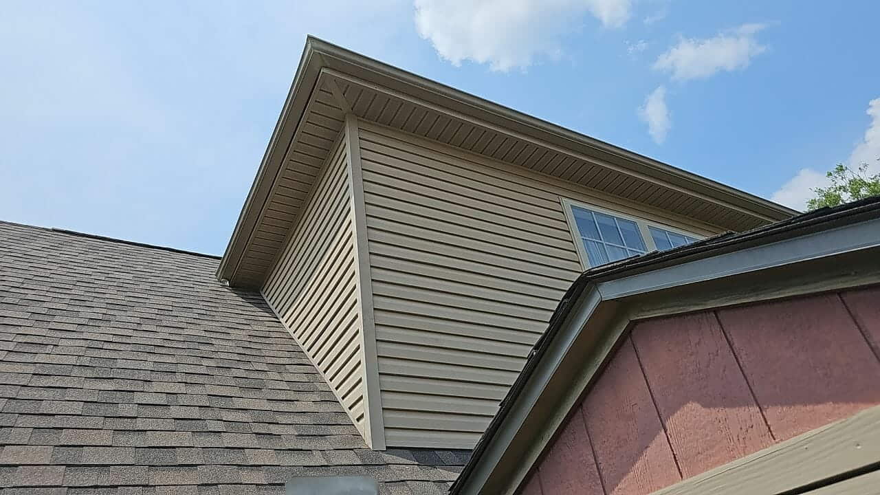 New shingle roof over a tan siding gable