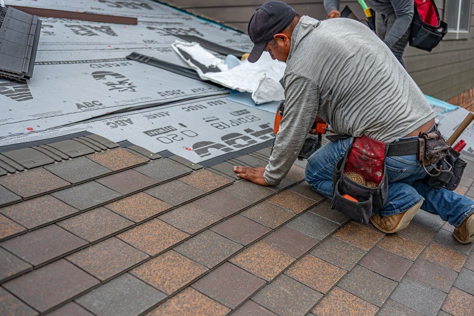roofing contractor inspecting shingles on a house in Little Rock AR roofing contractor inspecting shingles on a house in Little Rock AR