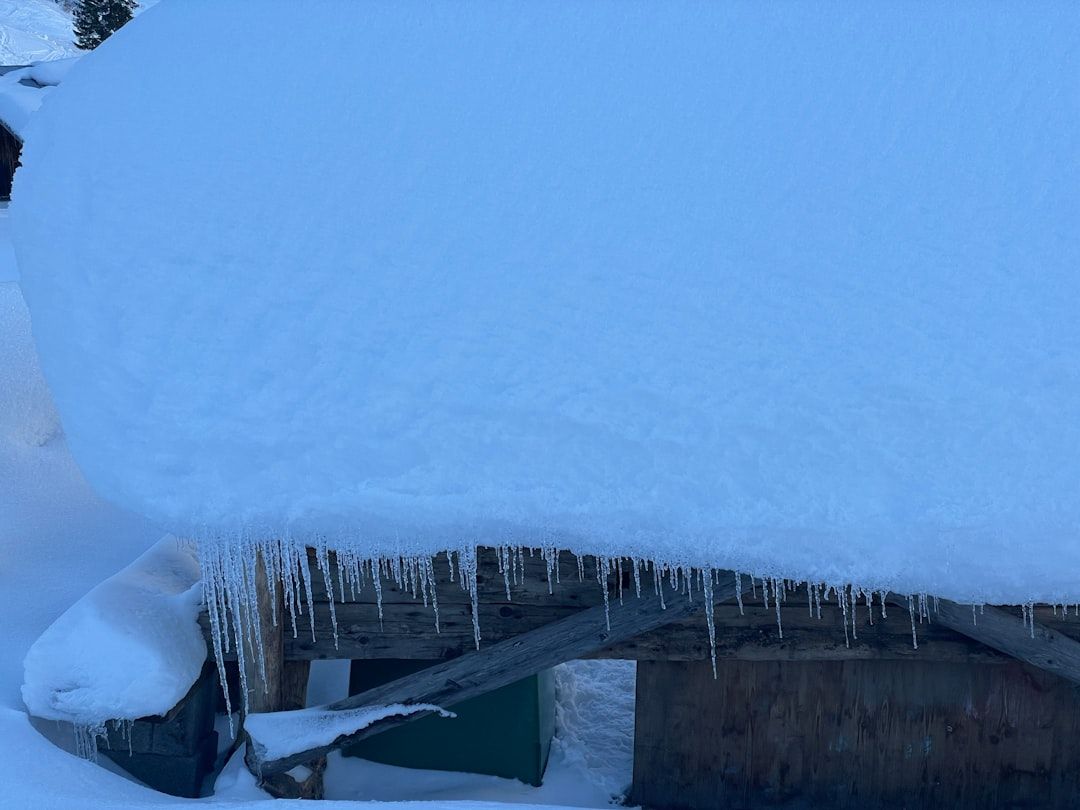 ice dam on roof edge with trapped water backing up under shingles ice dam on roof edge with trapped water backing up under shingles